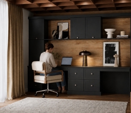 A combined wardrobe and working space with a women sat working on her laptop